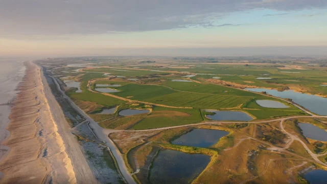 Vue aérienne sur le Hâble d'Ault durant le soleil couchant, seul le cordon de galet sépare le Hâble de la mer