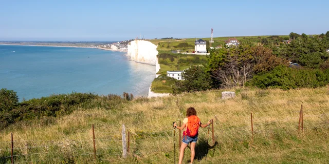 Randonneuse, sur le sentier du littoral, regardant le point de vue sur les falaises depuis les hauteurs du Bois de Cise