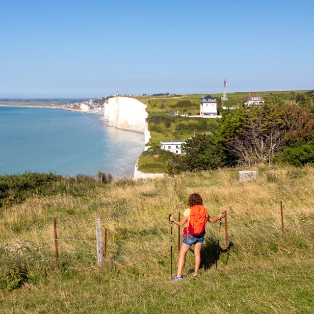 Randonneuse, sur le sentier du littoral, regardant le point de vue sur les falaises depuis les hauteurs du Bois de Cise